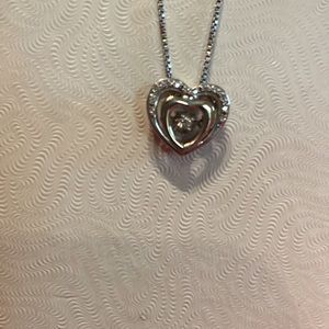 White gold and gold heart pendant with dancing diamond.